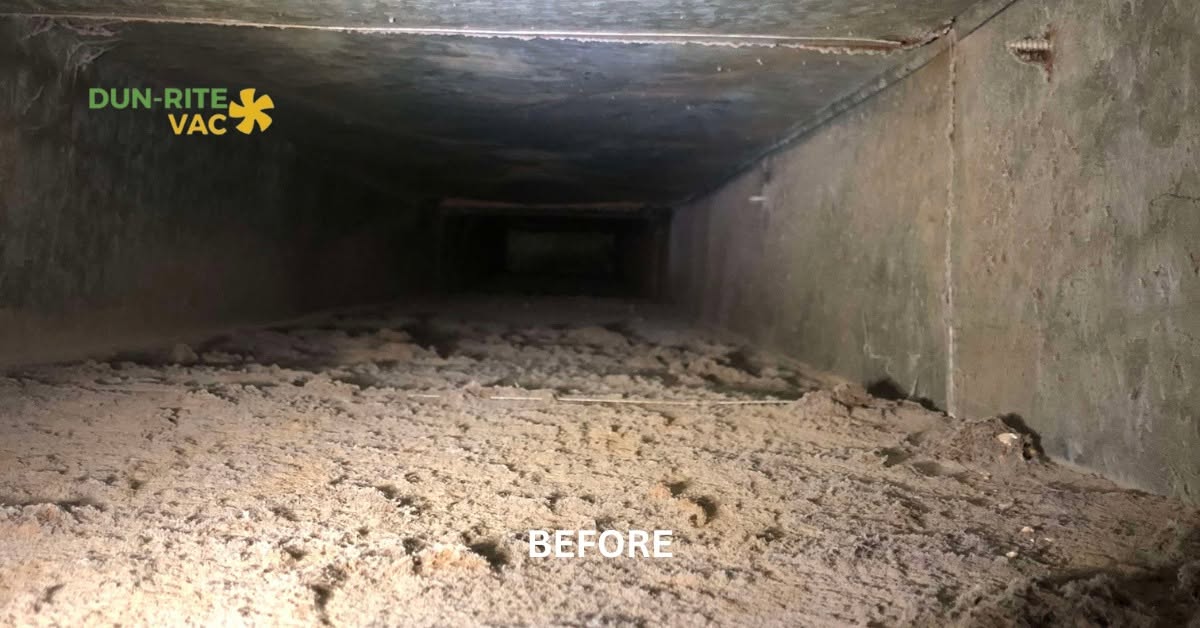 Interior of a main duct trunk line coated in thick dust buildup before professional cleaning