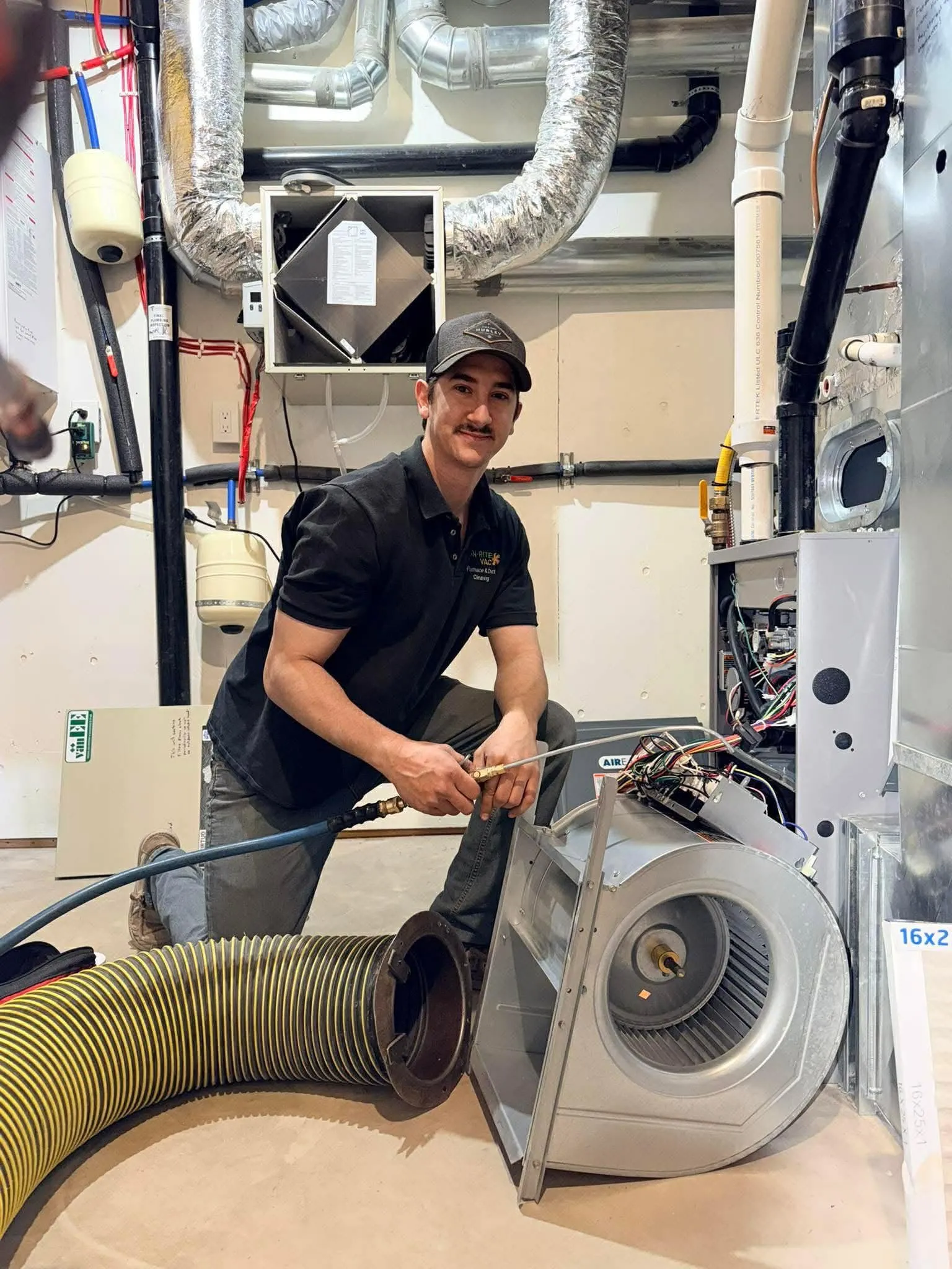 Technician cleaning a furnace blower during a complete air duct cleaning service.