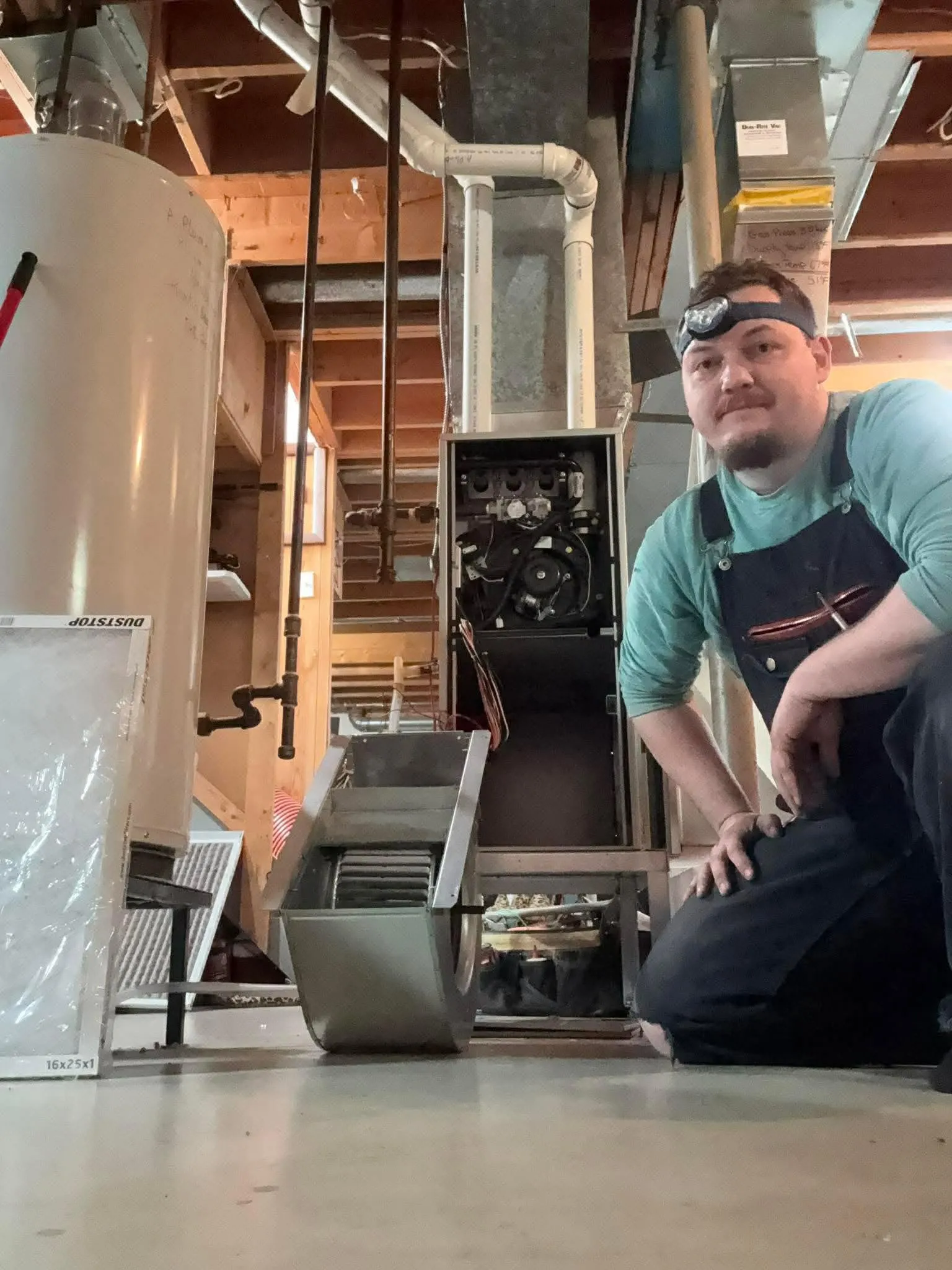 Dun-Rite Vac technician inspecting a home furnace system in a Yorkton basement.